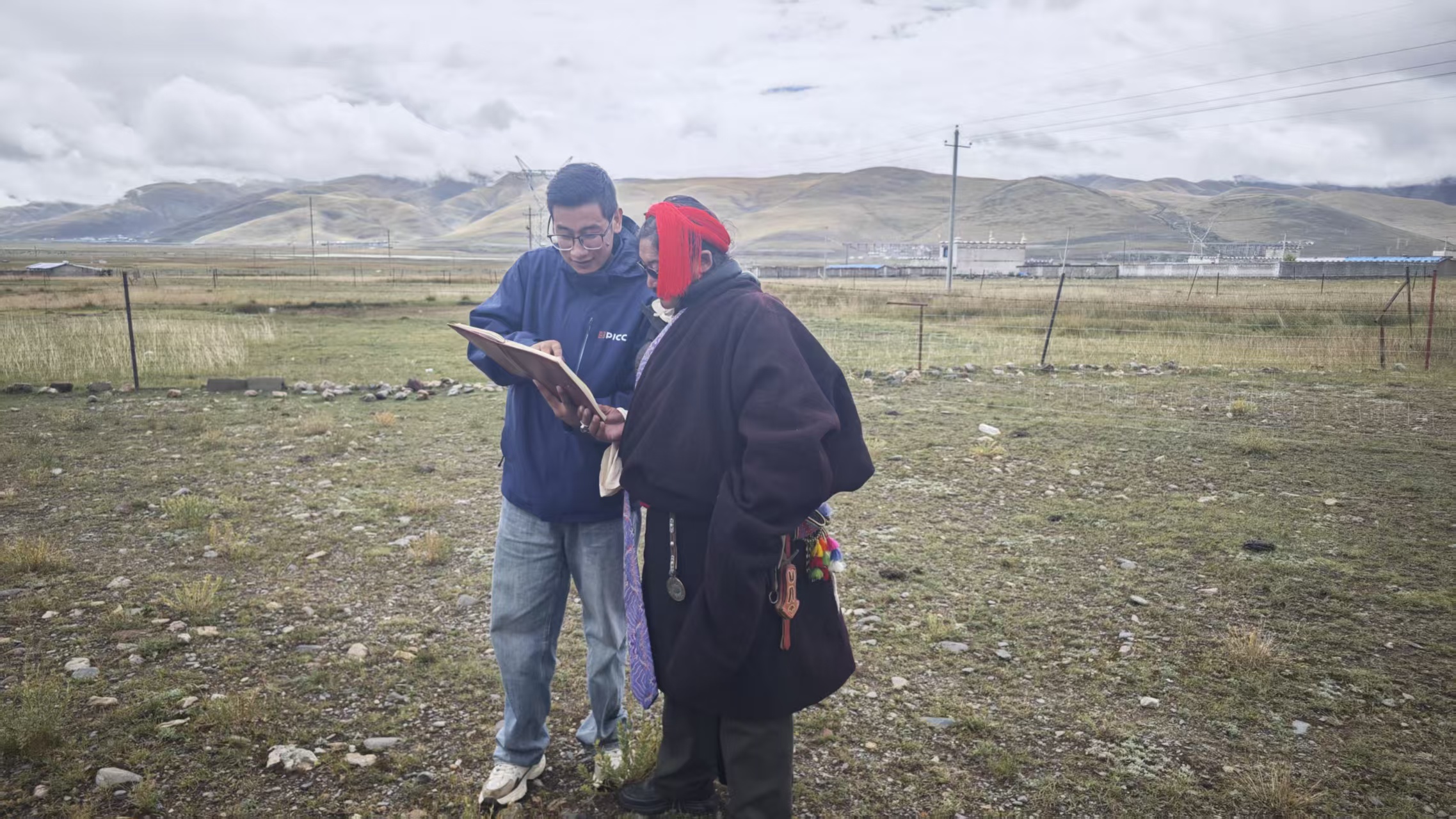 西藏当地保险工作人员在向当雄县牧民介绍理赔条款。 人民网记者 黄盛摄